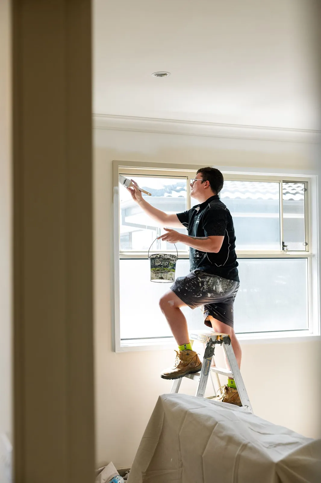 Platinum painter cutting in around a window frame
