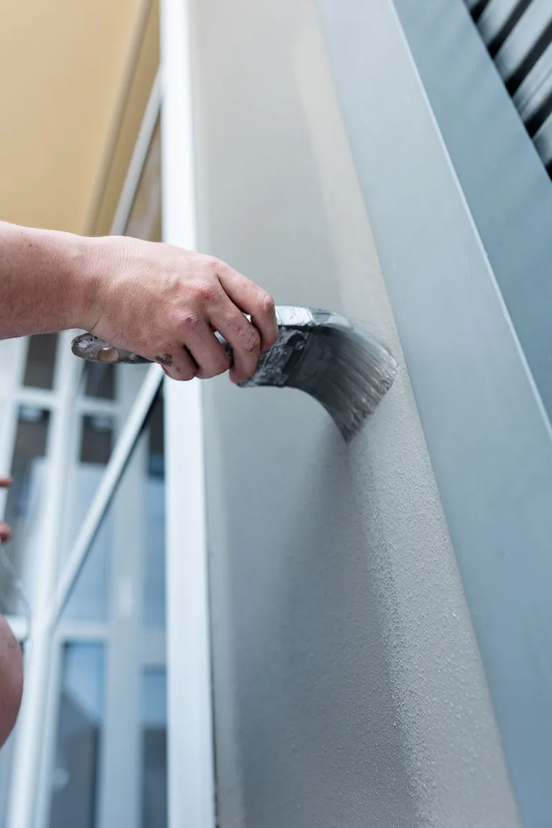 Close up of a paint brush working along a wall edge