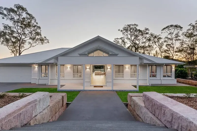 Single-storey Hamptons style home repainted, photographed at dusk