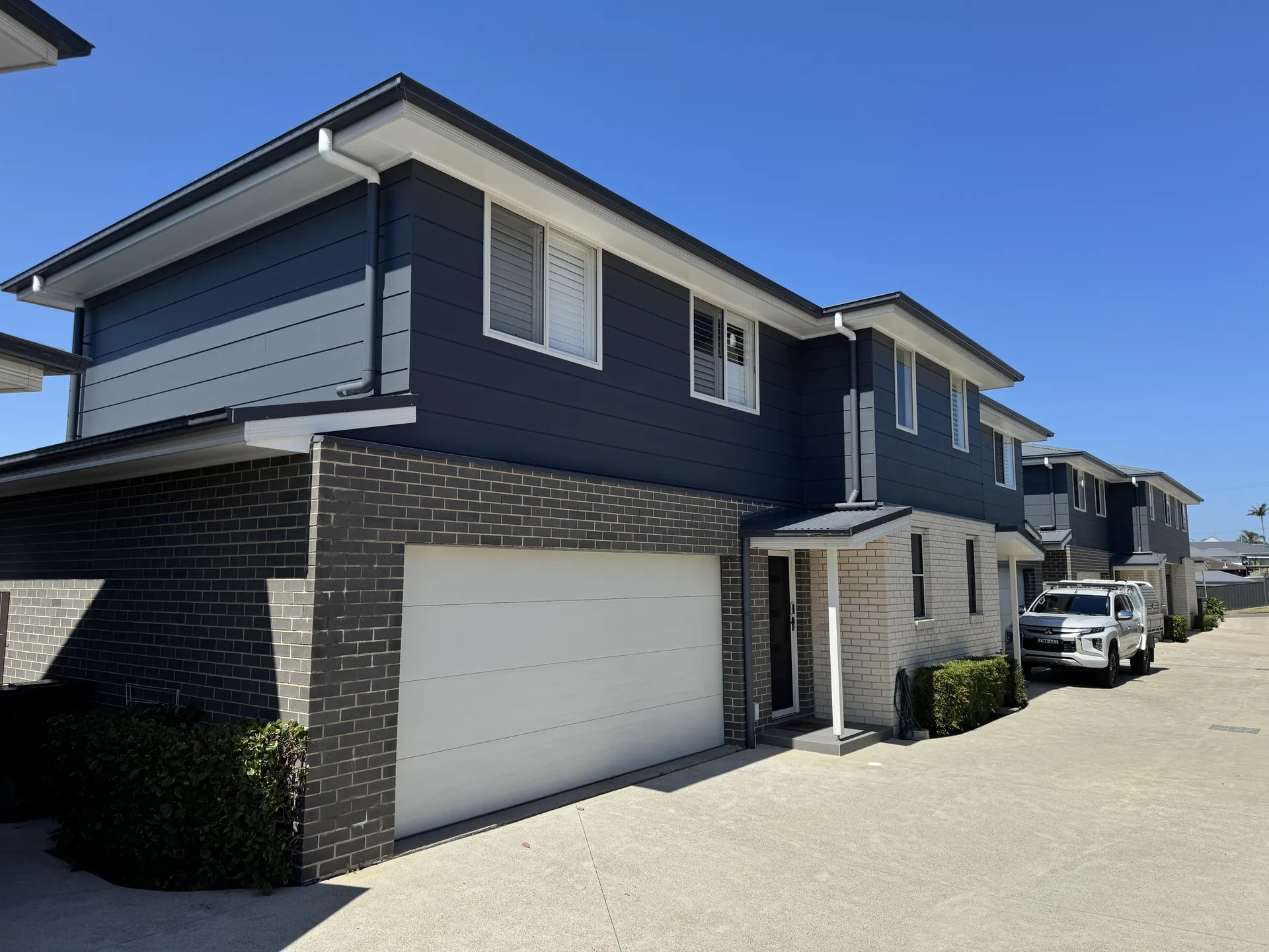 Row of navy and brick strata townhouses repainted by Platinum Painting