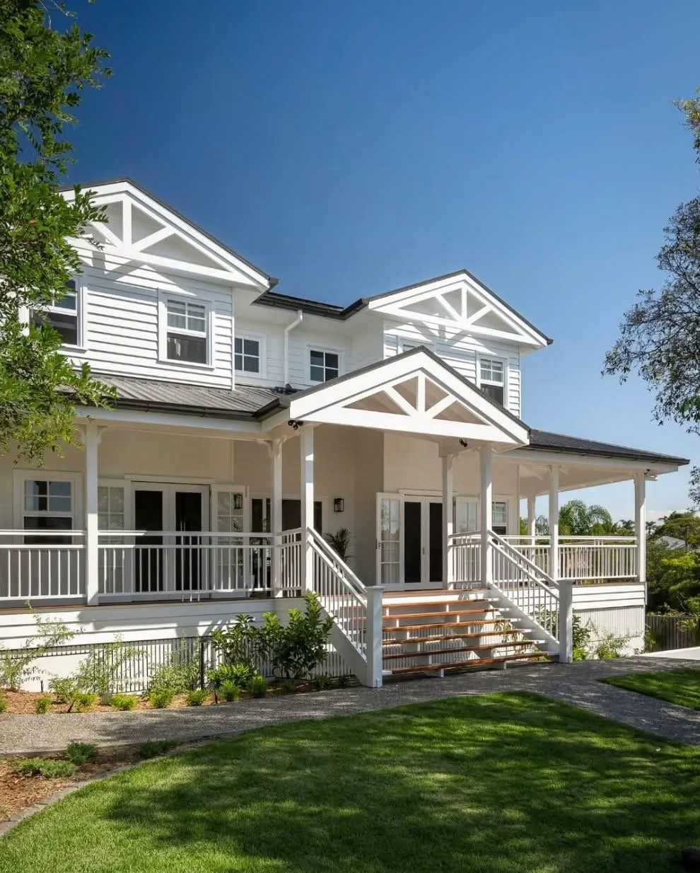 Two-storey Hamptons style home with fresh white exterior paint
